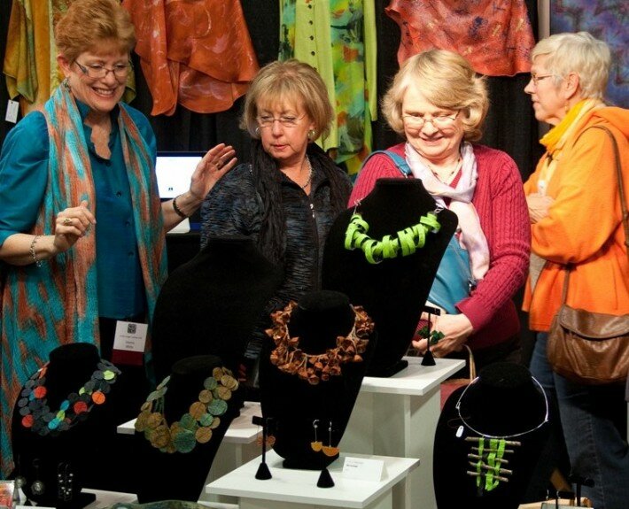 Collectors enjoy the wearable fiber of Joanna White and handmade jewelry by Nancy Raucch at the annual Carolina Artisan Craft Market in Raleigh, NC Nov. 6-8,2015.